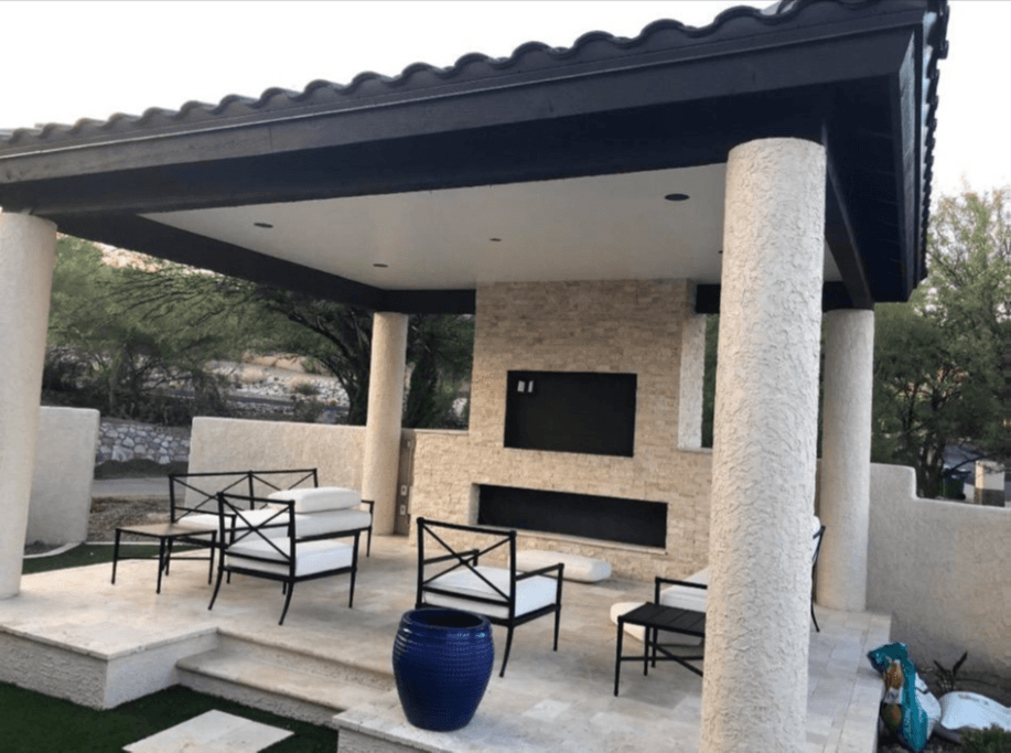 Covered outdoor living space with stone columns and pool