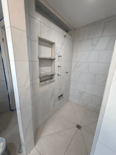 Marble-tile walk-in shower with built-in niche