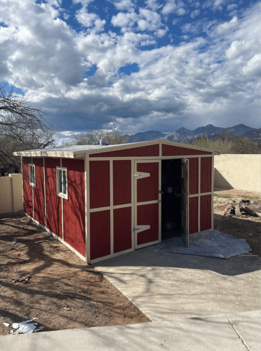 Red storage shed with white trim